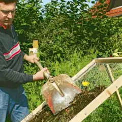 Man skopar kompost i en sil. Egen kompost ger näringsrik jord till trädgården.