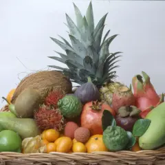 En korg fylld med exotiska frukter, inklusive en ananas som ser ut att vara redo att plantera.