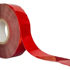 En rulle med röd, reflekterande tejp som rullas ut. Perfekt för att öka synligheten i mörker.