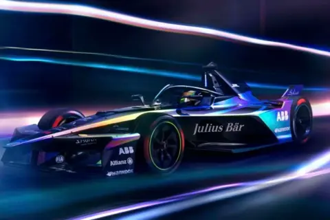 En futuristisk Formel E-bil, med texten "Julius Bär" och "ABB", susar fram i neonljus. F1 frön för framtiden.