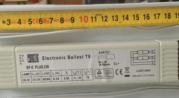 En elektronisk ballast, Practic Line EF-E PLUS 236, med en mätsticka som visar 20 cm.