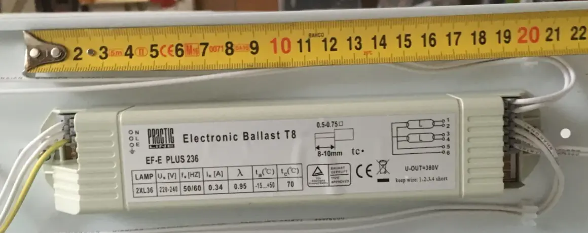 En elektronisk ballast, Practic Line EF-E PLUS 236, med en mätsticka som visar 20 cm.