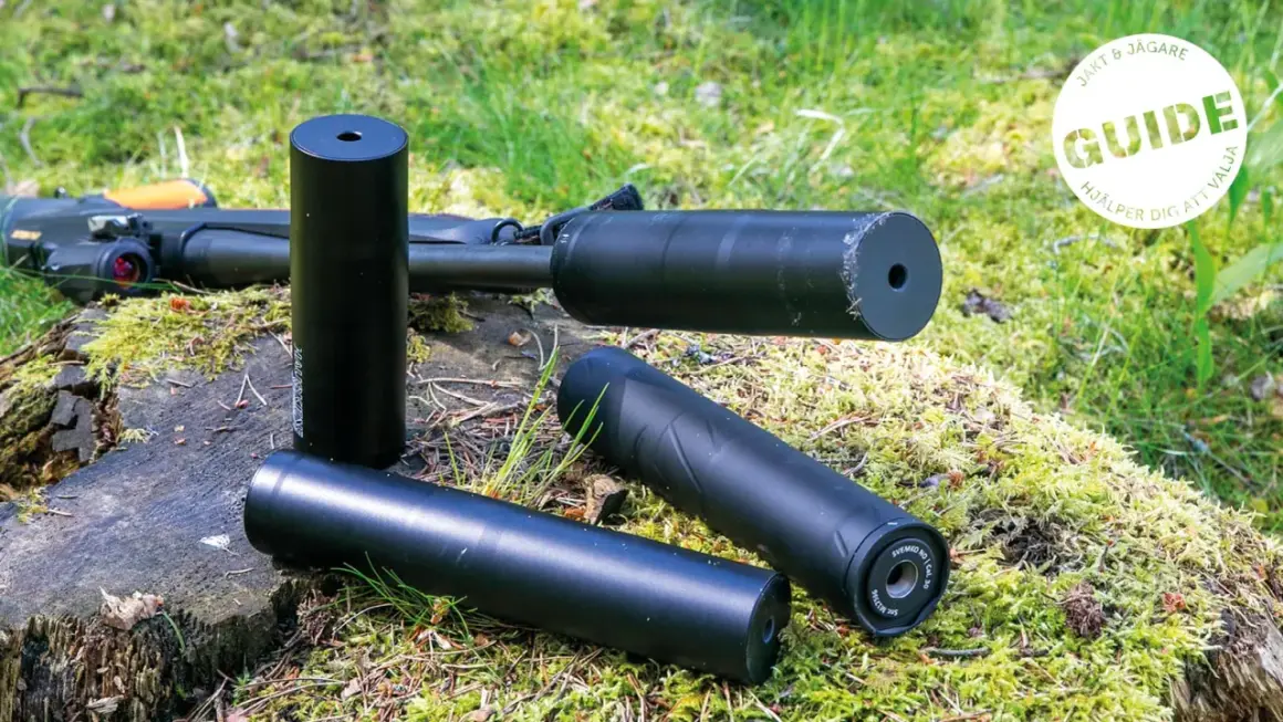 Tre ljuddämpare för jakt, en 125 mm, ligger på en mossig stubbe bredvid ett gevär. En guide hjälper dig att välja rätt.