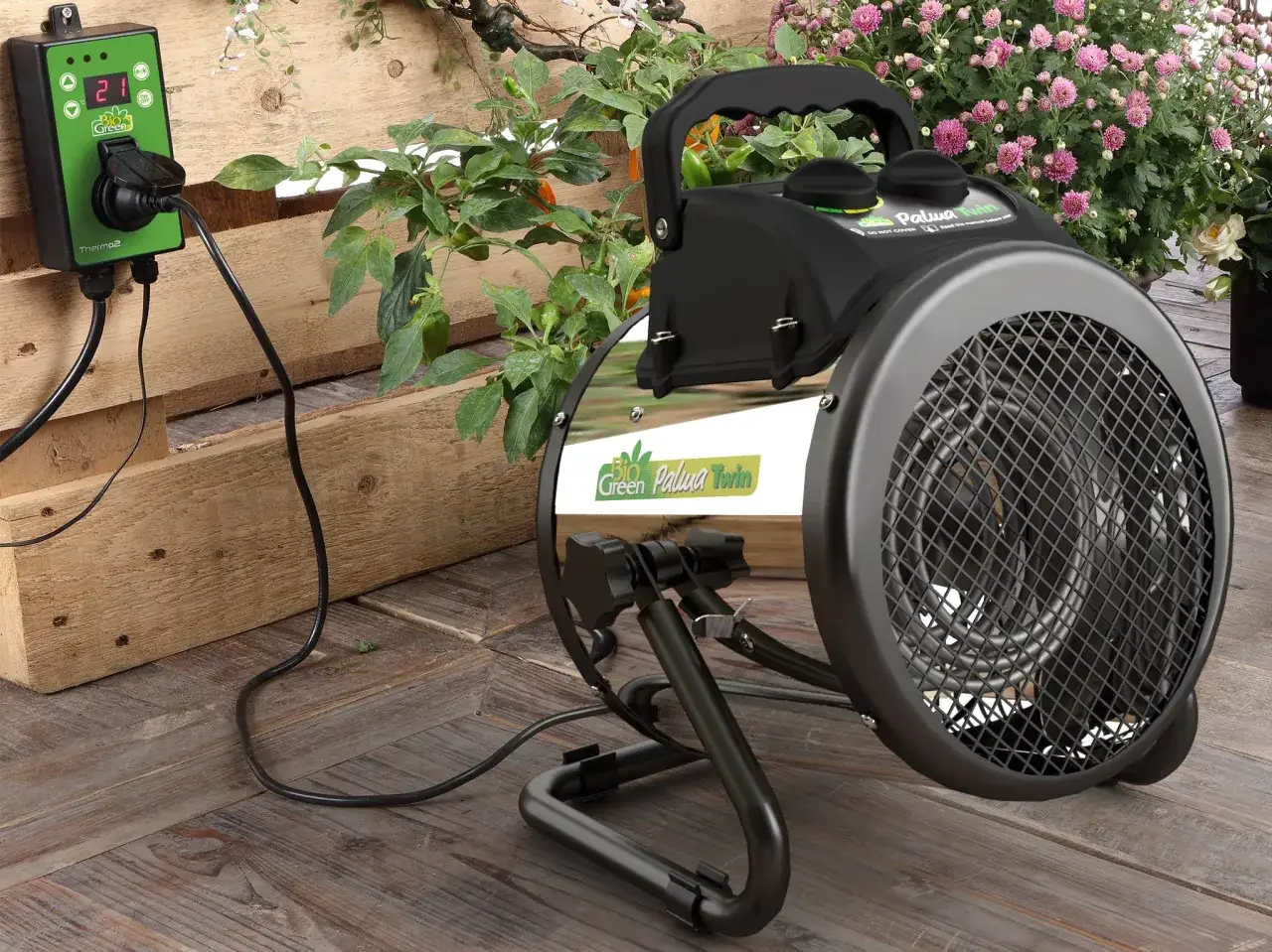 En grön termostat kopplad till en värmefläkt, perfekt för att ge dina växter den värme de behöver med ecoheat.