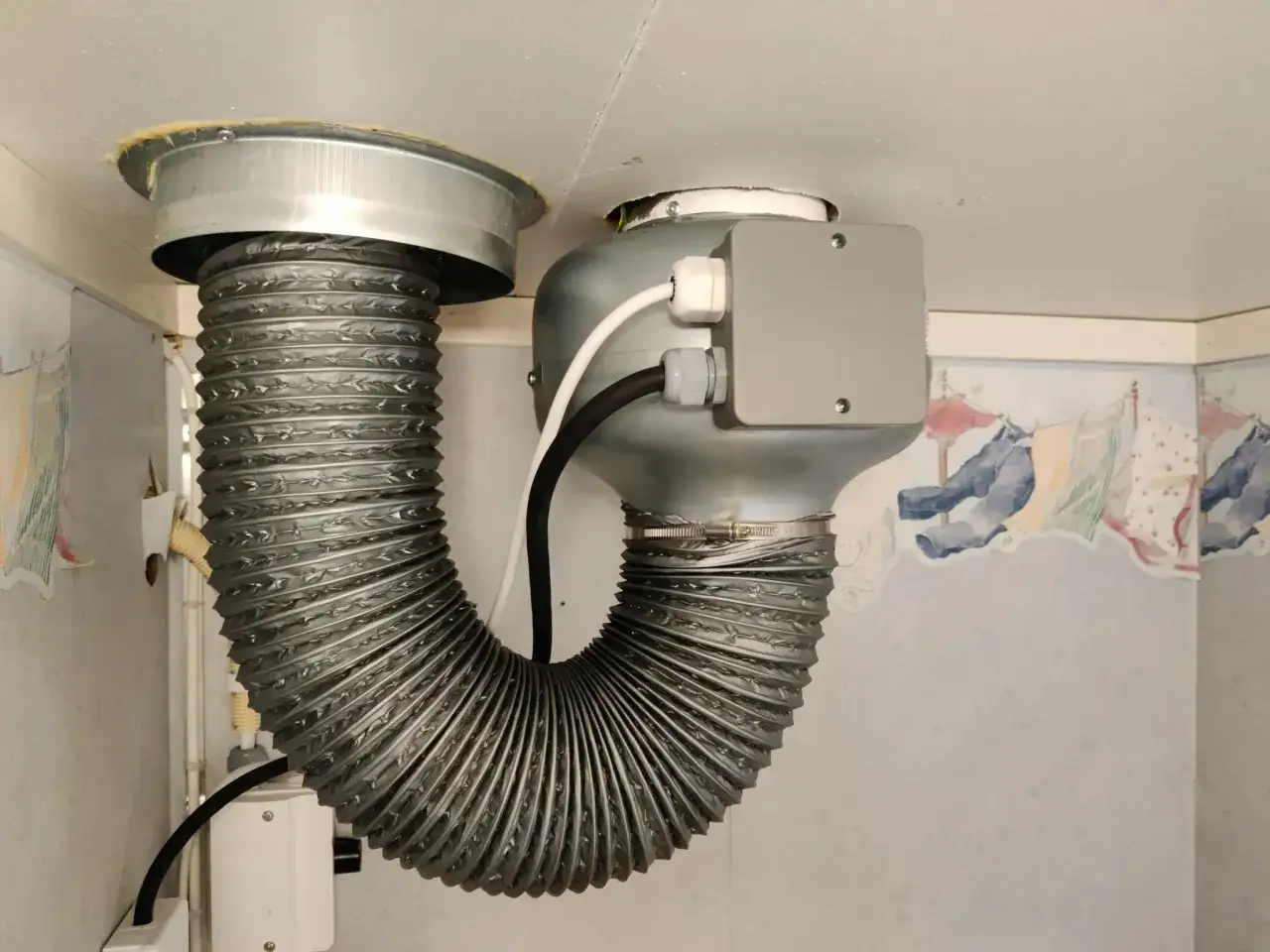 Ventilation ljuddämpare 125 mm, en flexibel slang ansluten till en fläkt med en grå kopplingsdosa.